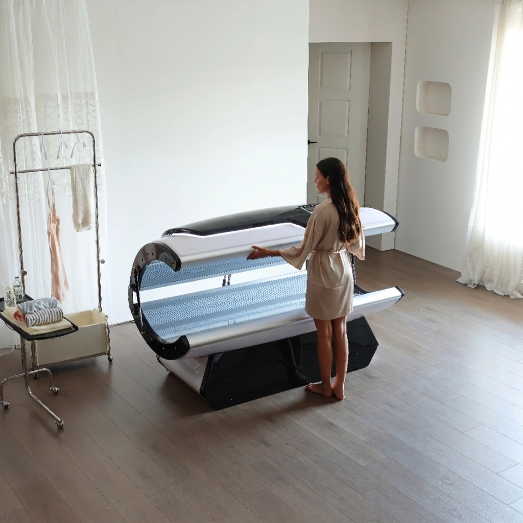 Client opening the canopy of the full-body LED capsule in a bright studio